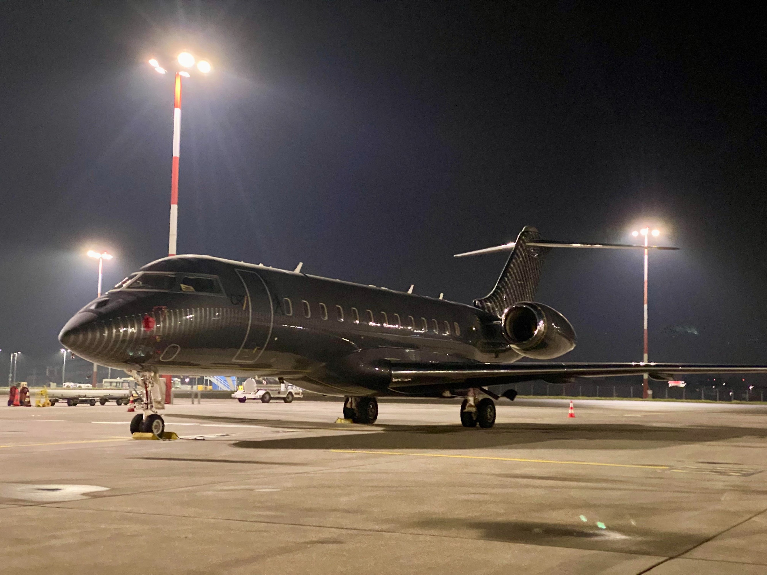 Jet privé Bombardier Global Express noir de Cristiano Ronaldo, aux initiales CR7, stationné de nuit sur le tarmac sous les projecteurs