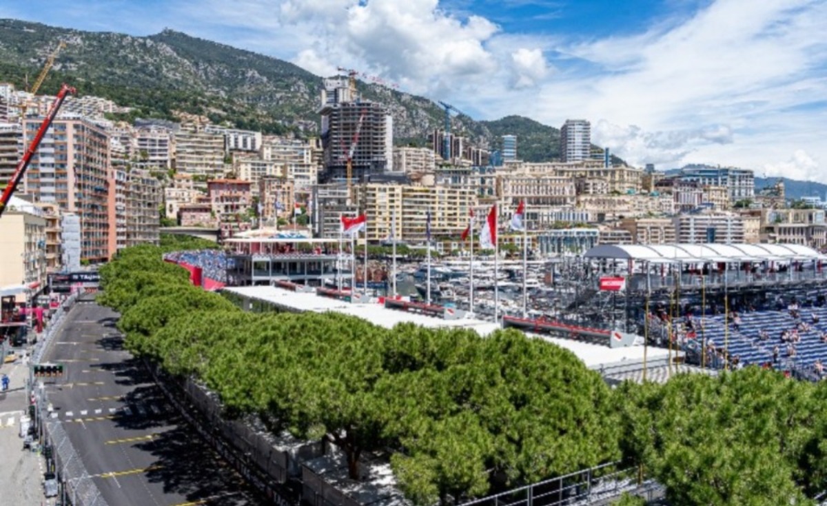 Vue panoramique du circuit du Grand Prix de Monaco depuis les hauteurs — tribunes, port et yachts, ligne droite des stands avec panneaux TAG Heuer