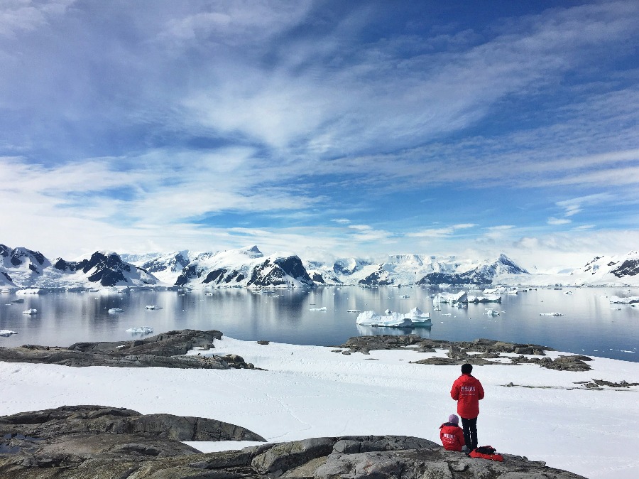 Avion pose sur une piste de glace bleue en Antarctique au pied de montagnes enneigees