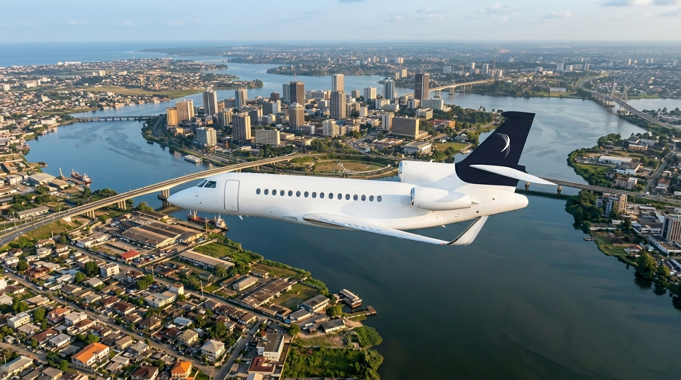 Jet privé Dassault Falcon d'IBC Aviation survolant Abidjan : la lagune Ébrié, les tours du Plateau et le pont à haubans.