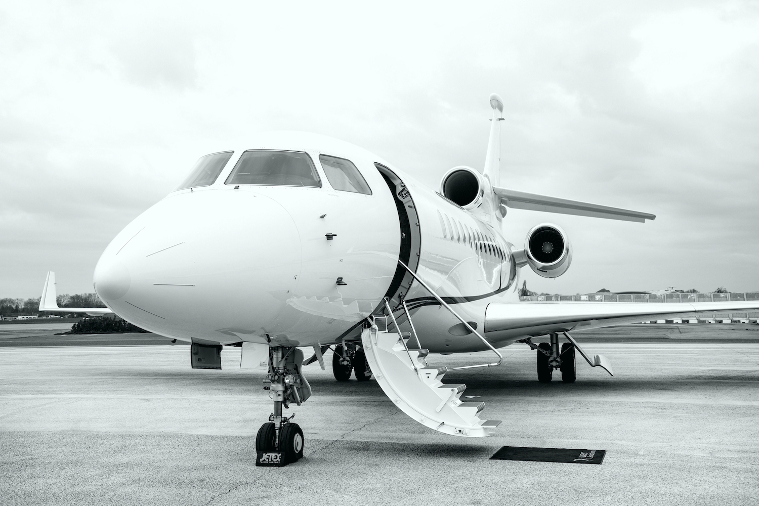 Jet privé stationné avec sa porte ouverte et son escalier déployé.