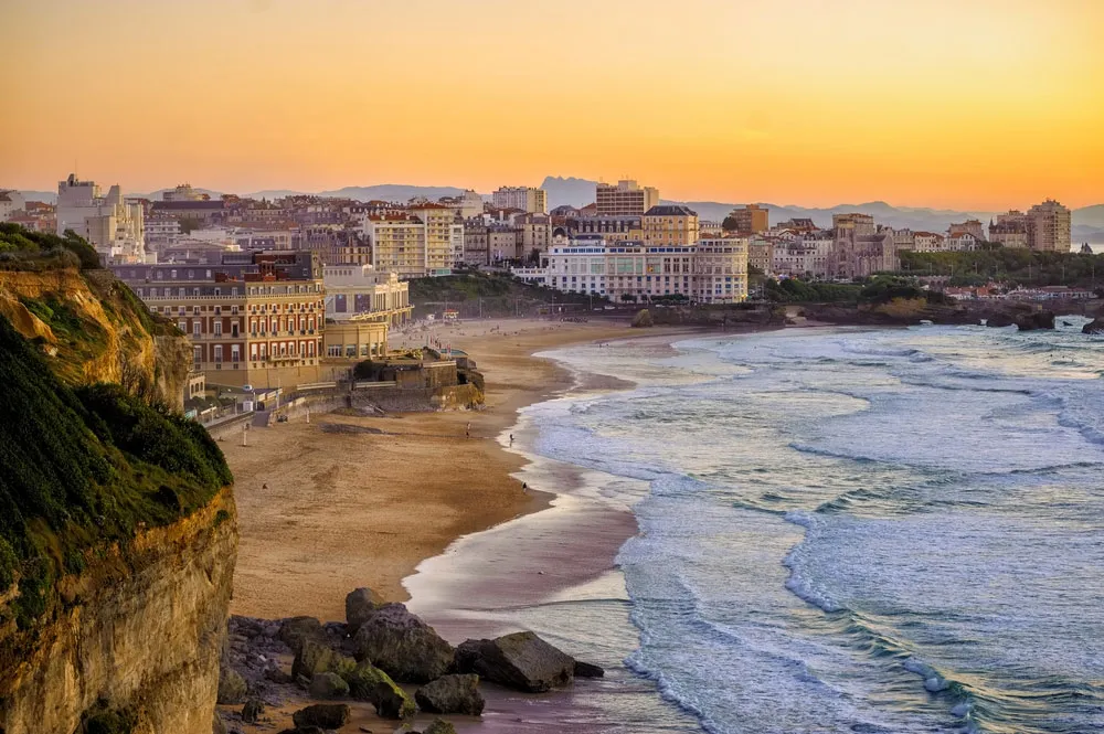 Voyagez en jet privé vers Biarritz magnifique paysage avec l'océan Atlantique à la droite et les falaises et bâtiments historiques de cette ville à la gauche de l'image