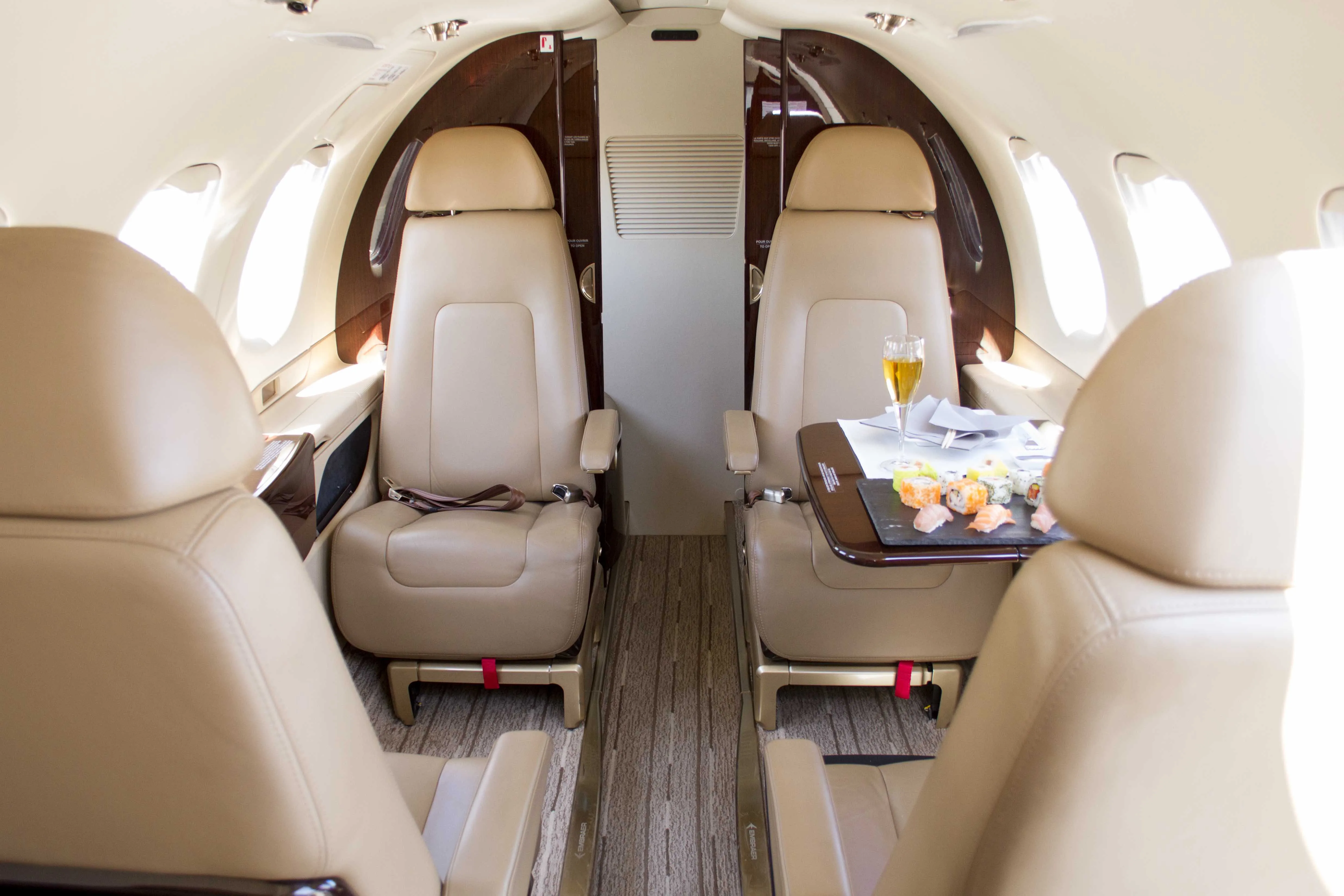 Fauteuils et couloir central dans une cabine de jet privé.